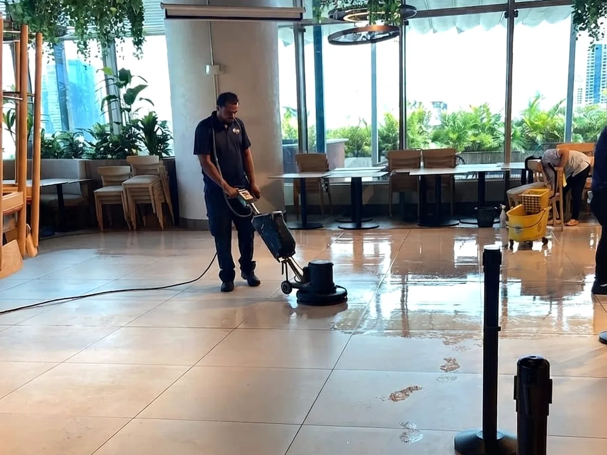 Personal de Go Services puliendo el piso de un lobby corporativo